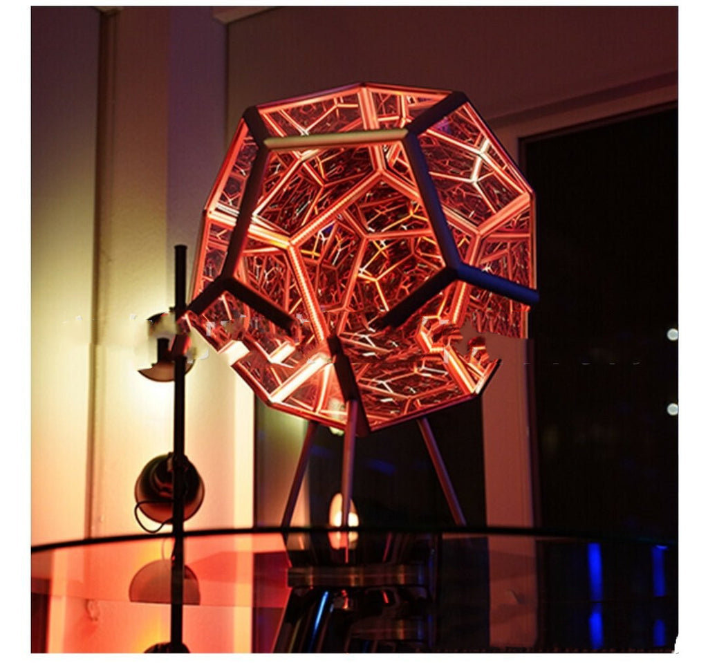 Modern geometric table lamp with red and orange light on a reflective surface.